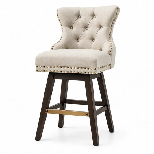 Taburete de bar tapizado en tejido beige con respaldo capitoné y tachuelas estructura de madera maciza patas marrón oscuro con reposapiés metálico dorado